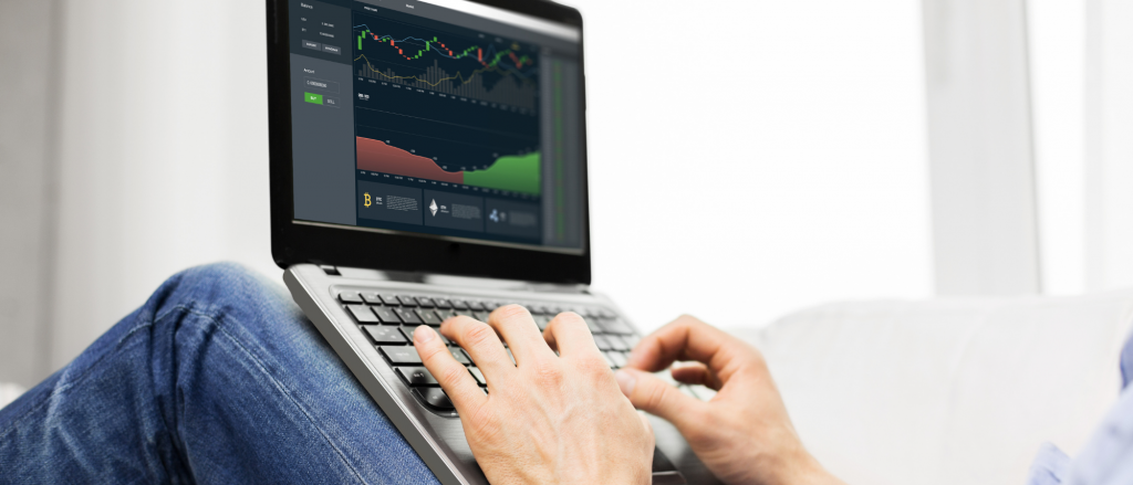 A trader seated working on his laptop trading BTC and ETH