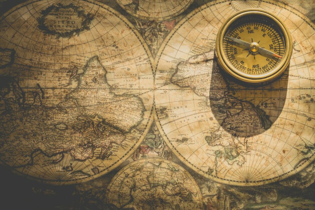 An old map with a compass in the top right corner. Image courtesy of Ylanite Koppens at Pexels. 